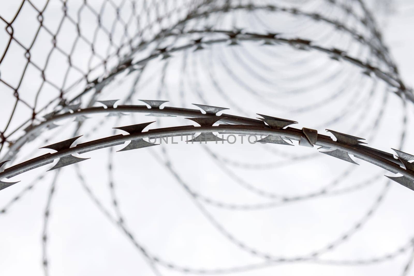 Fence with a barbed wire under a blue sky