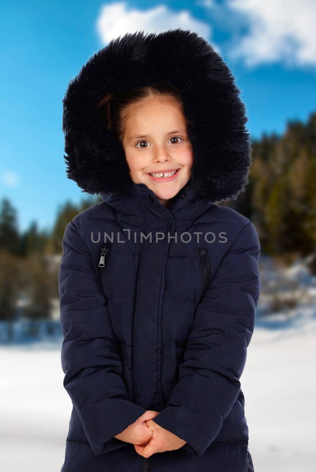 Sheltered girl with black coat and hood in a cold and snowed day
