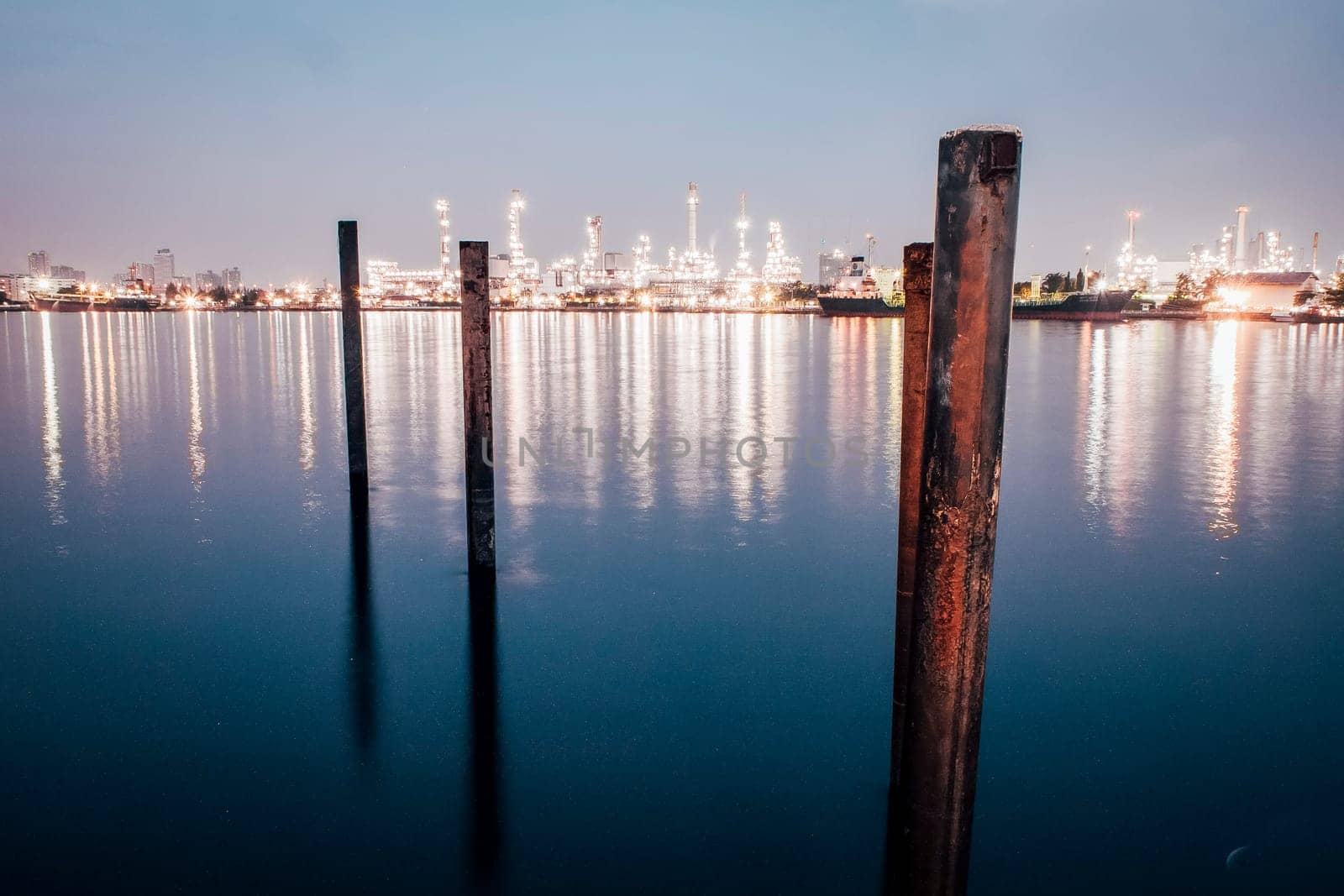 Cityscape industrial area at night and reflection in the river. Town Lake mirrored reflection