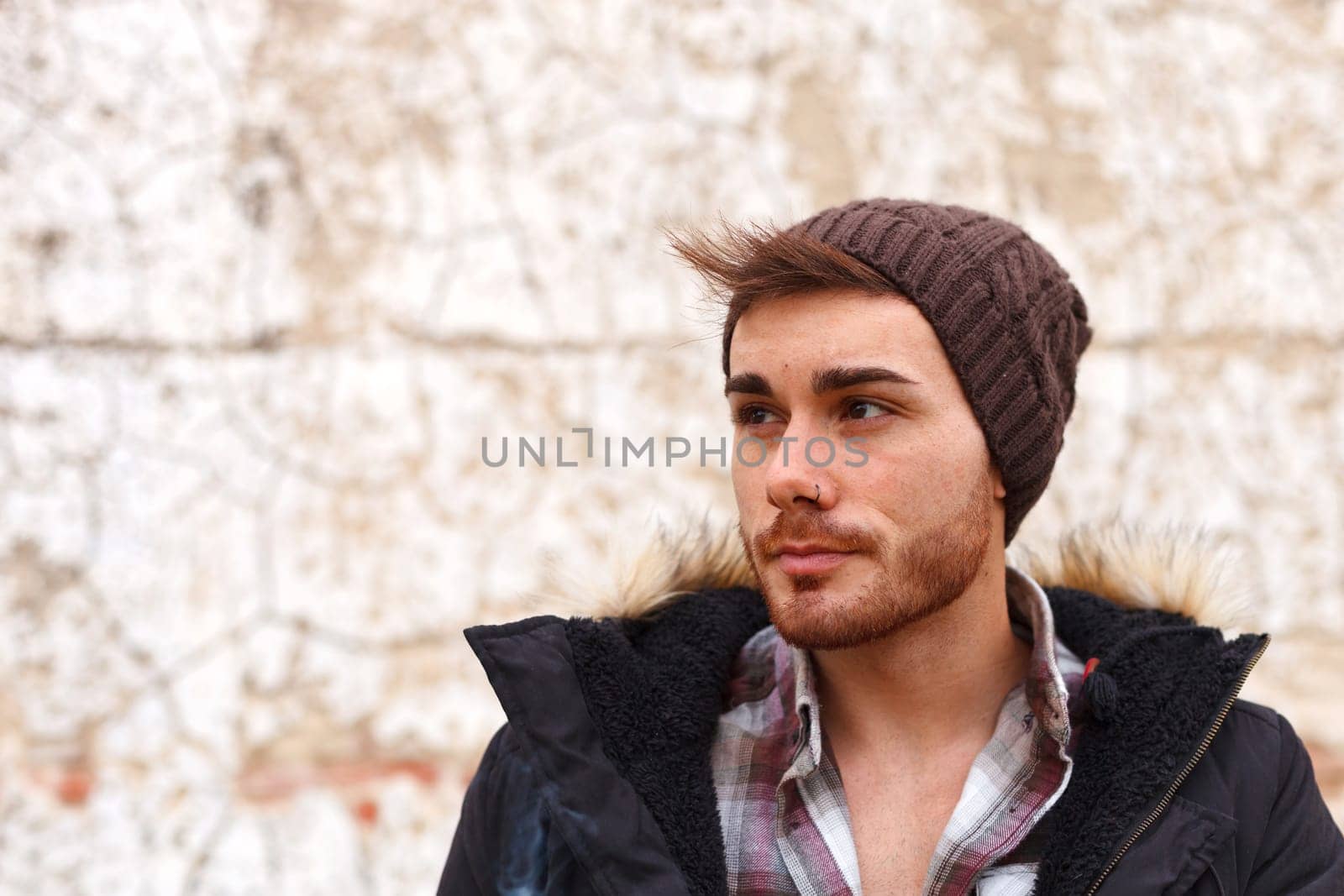 Sad guy with wool hat wearing a dark coat