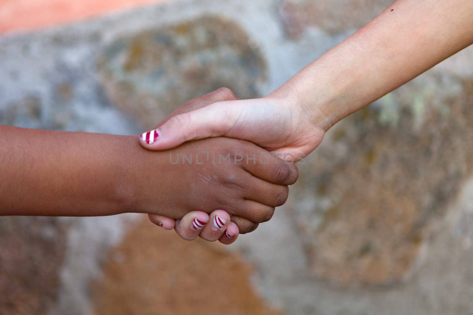 Two children´s hands of differents races together shaking