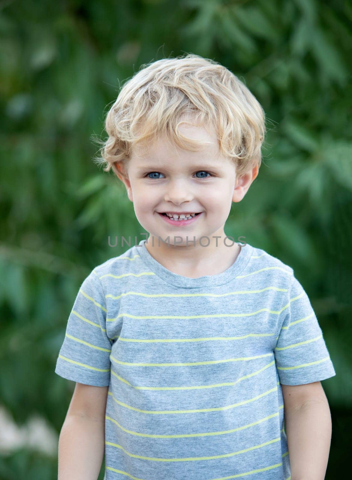 Happy child with blue t-shirt playing in the garden