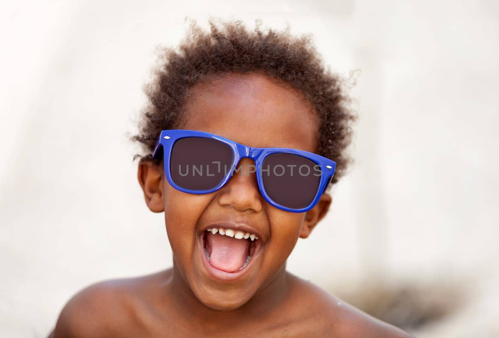 Funny Afro-American kid with blue sunglasses and a beautiful smile