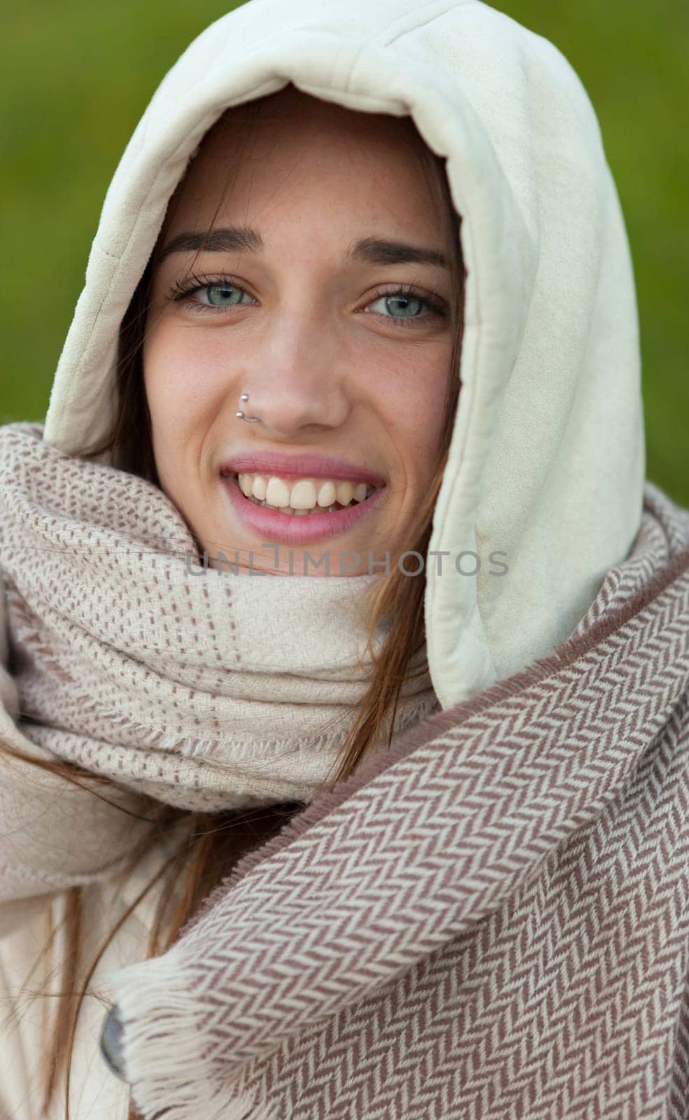 Sheltered girl with hood and scarf in the park