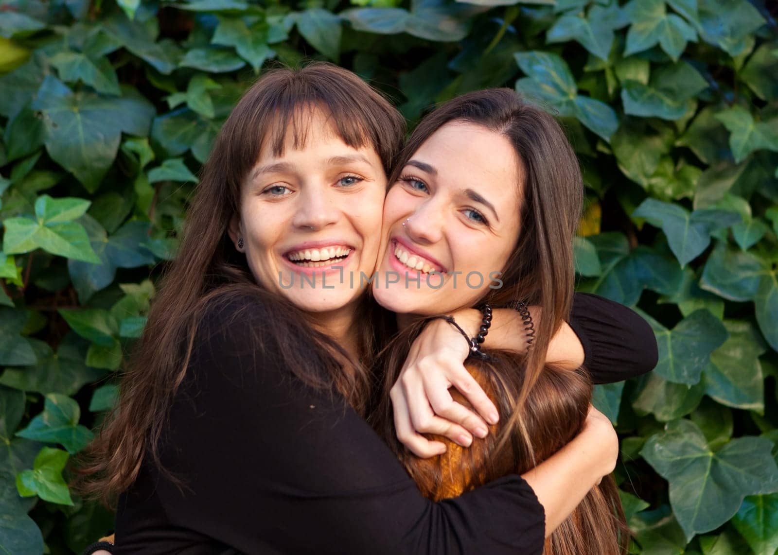Outdoor portrait of two happy sisters relaxed in a park