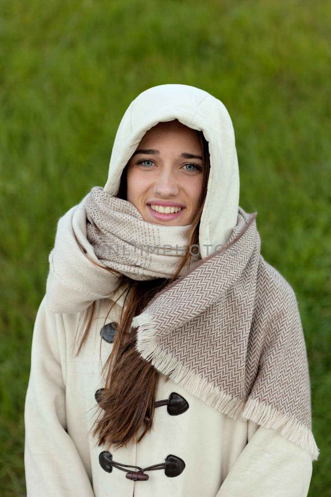Sheltered girl with hood and scarf in the park