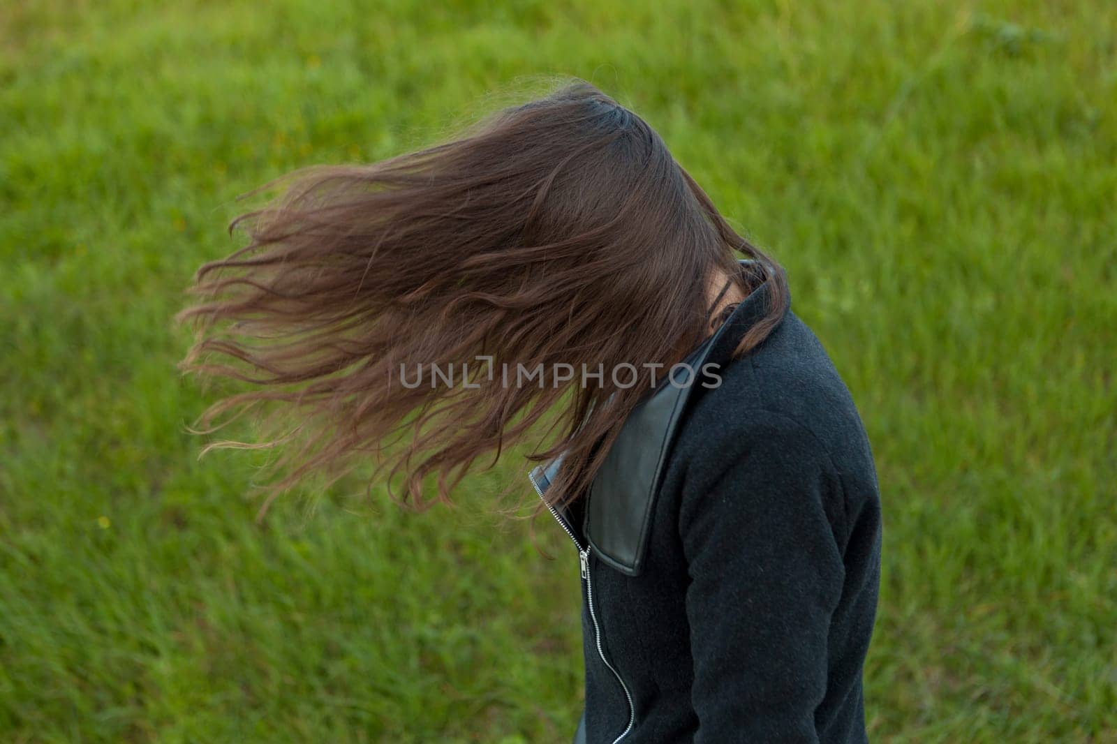 Outdoor portrait of beautiful happy girl laughing while the wind moves her hair