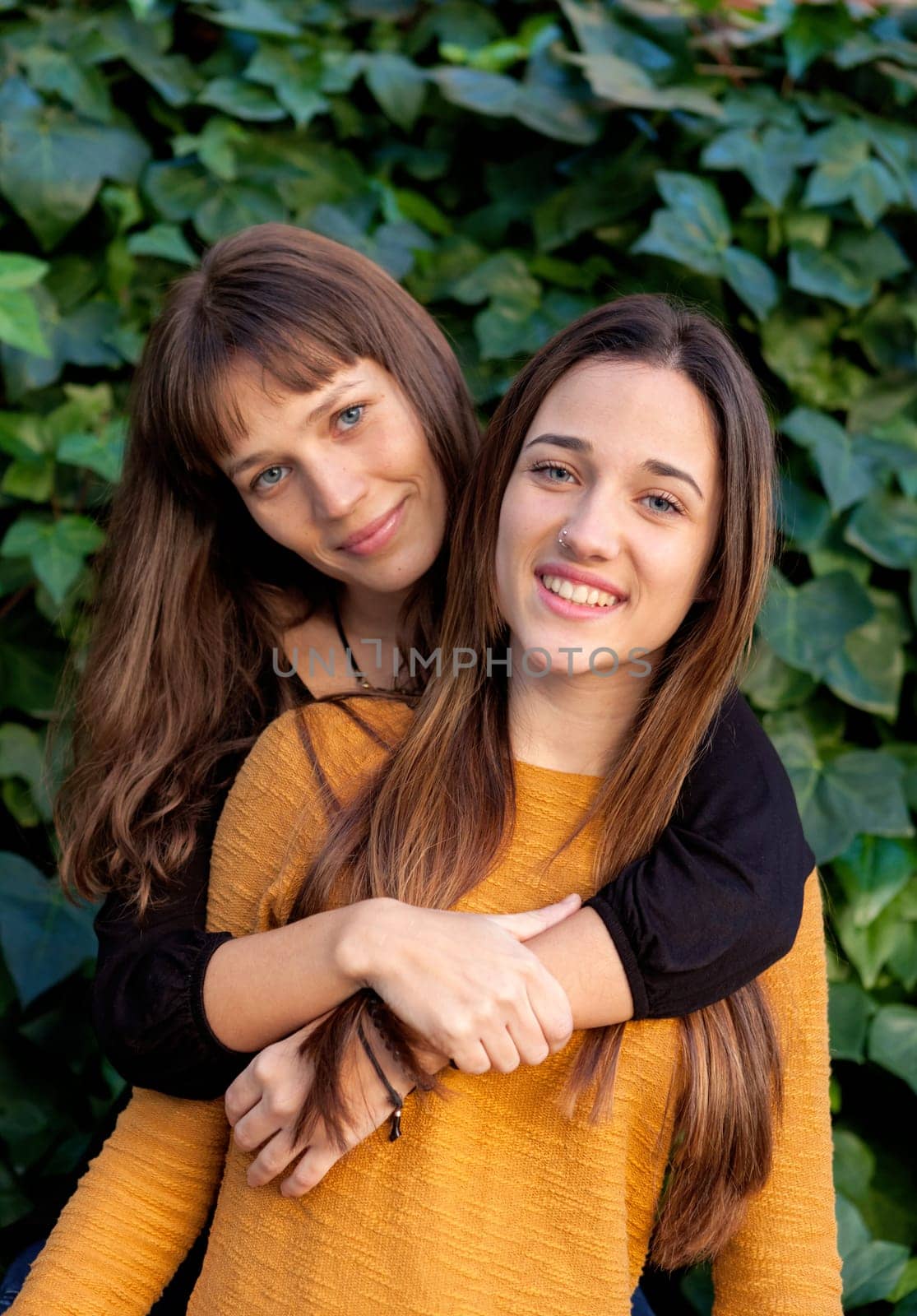 Outdoor portrait of two happy sisters relaxed in a park