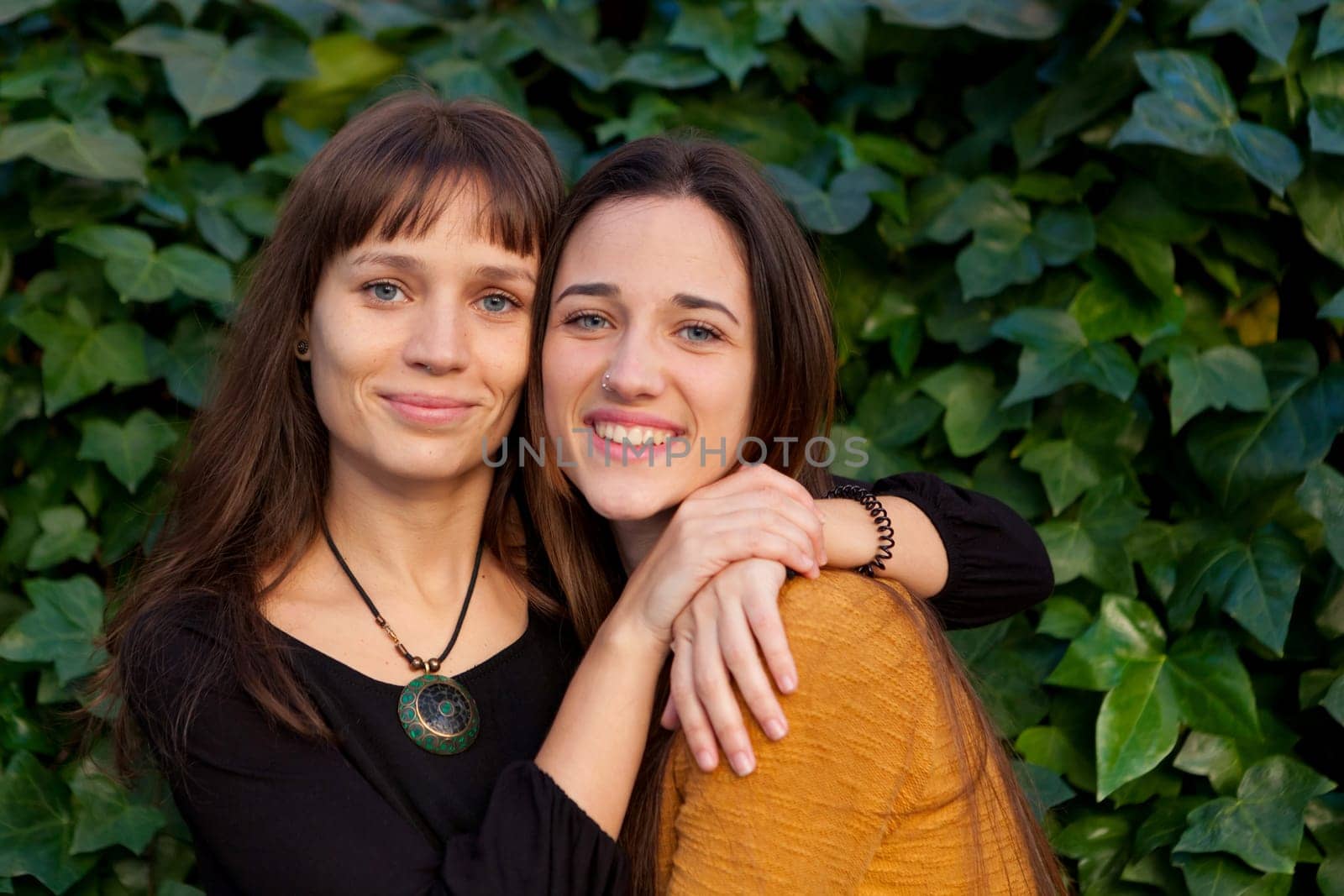 Outdoor portrait of two happy sisters relaxed in a park