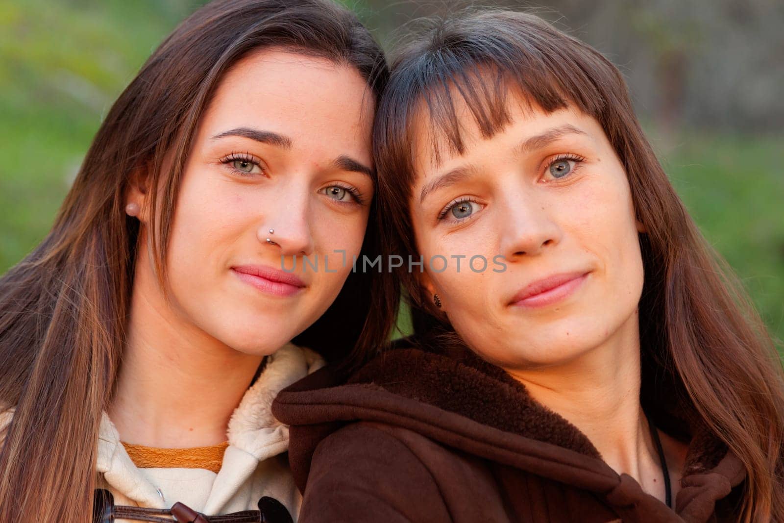 Nice sisters with blue eyes in a park