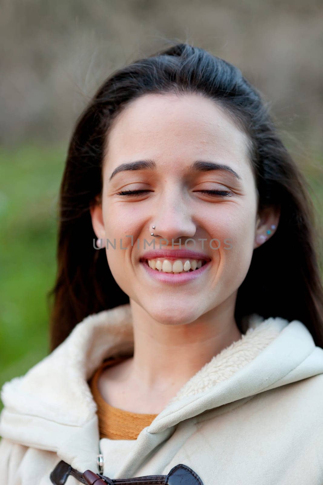 Smiling teen girl outside with a natural green of background