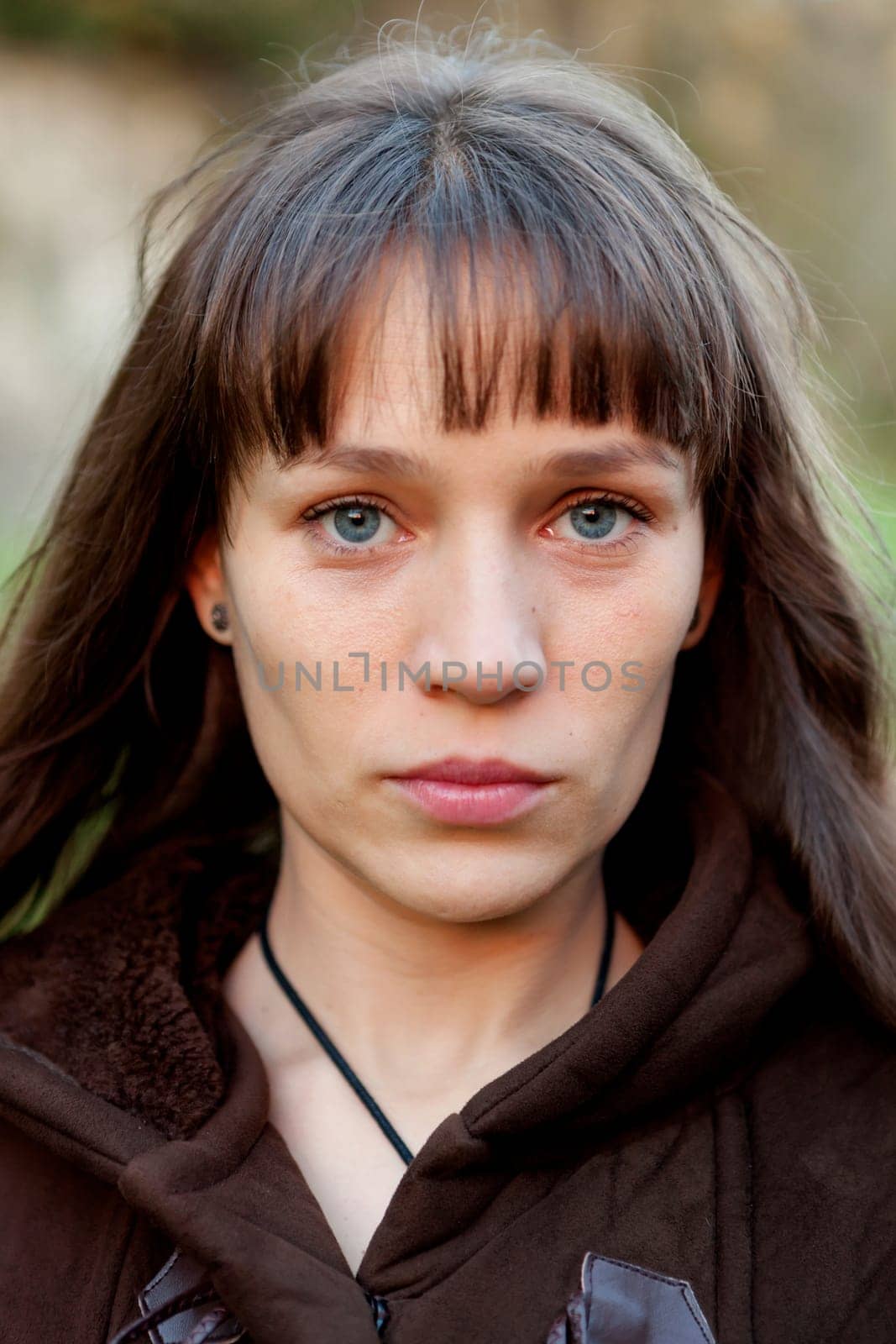 Beautiful brunette woman with blue eyes in the park