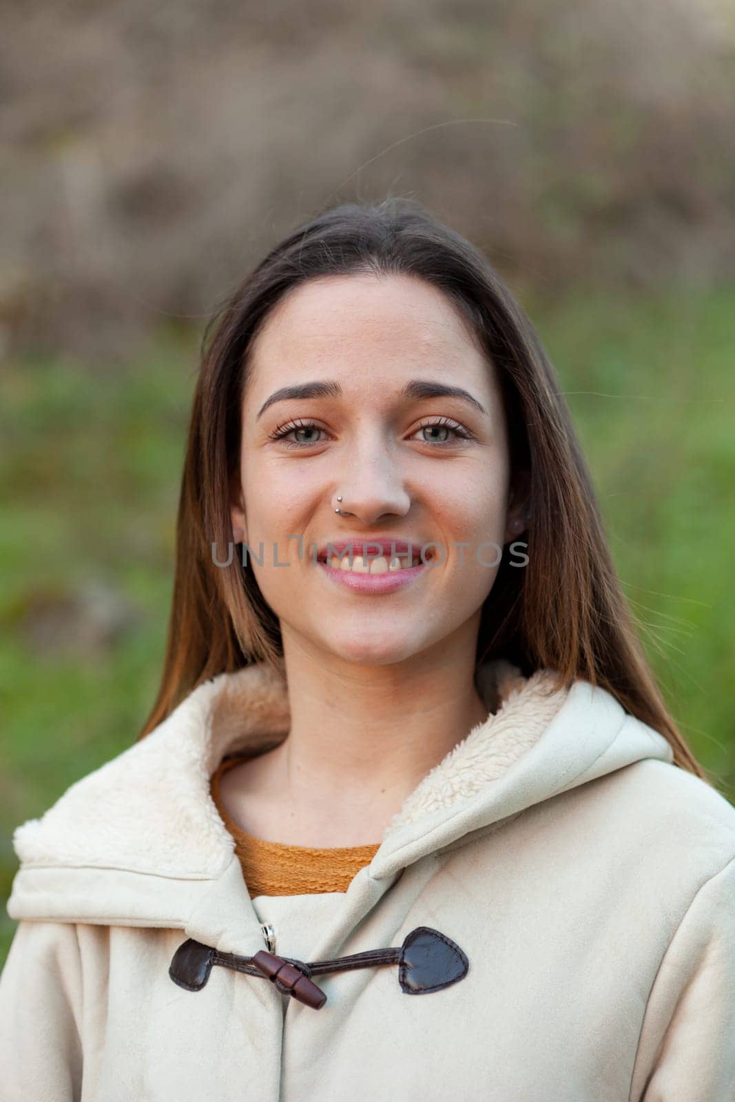 Smiling teen girl outside with a natural green of background