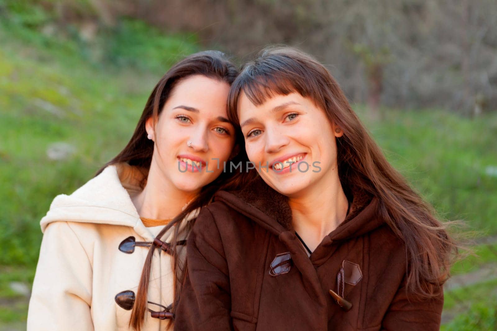 Nice sisters with blue eyes in a park