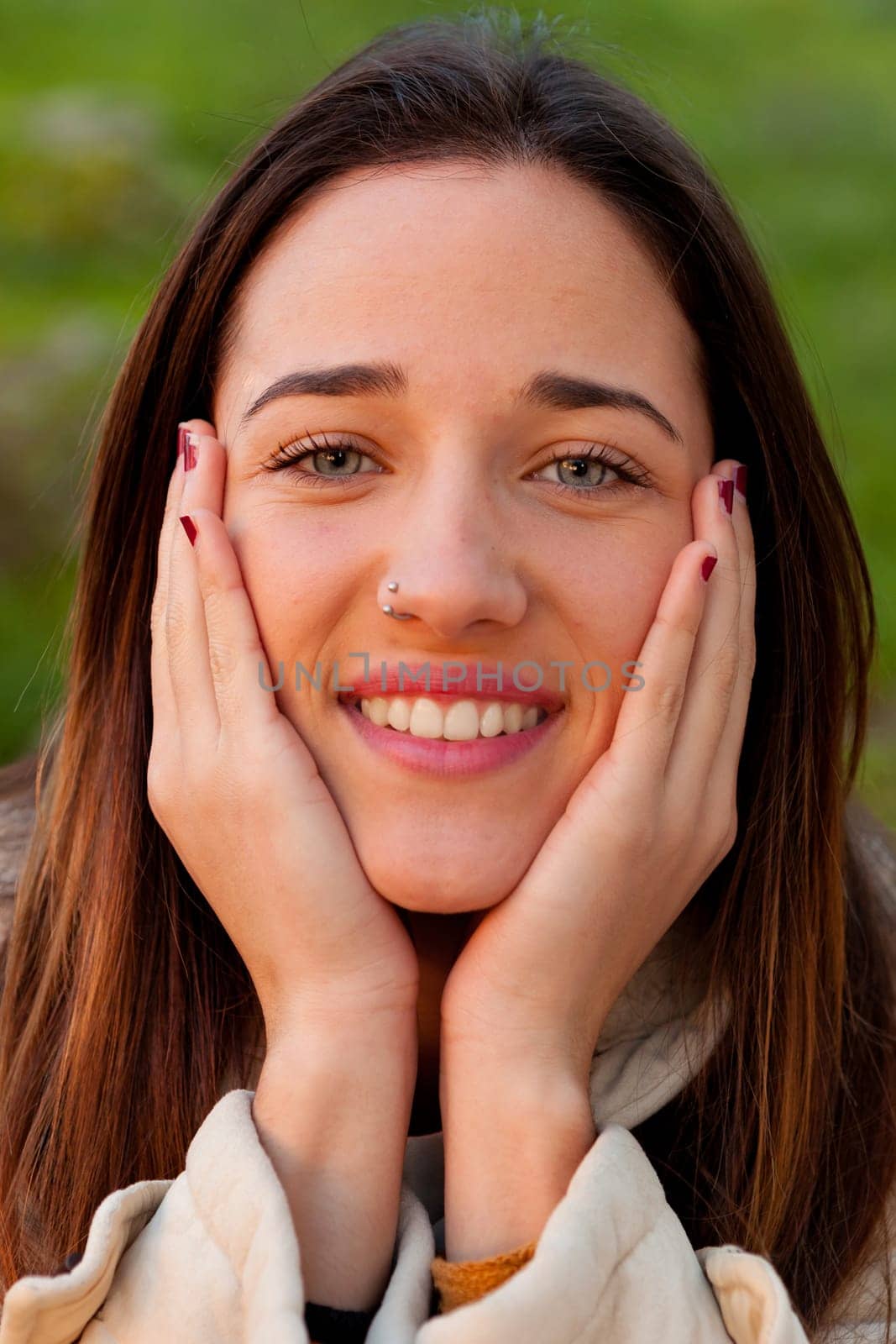 Smiling teen girl outside with a natural green of background