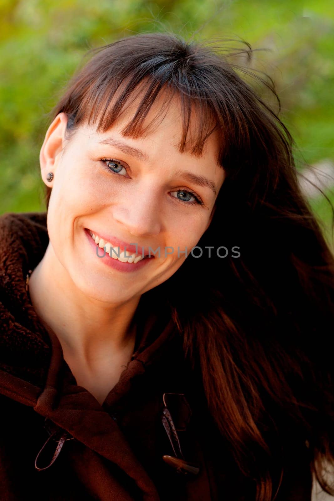 Beautiful brunette woman with blue eyes in the park
