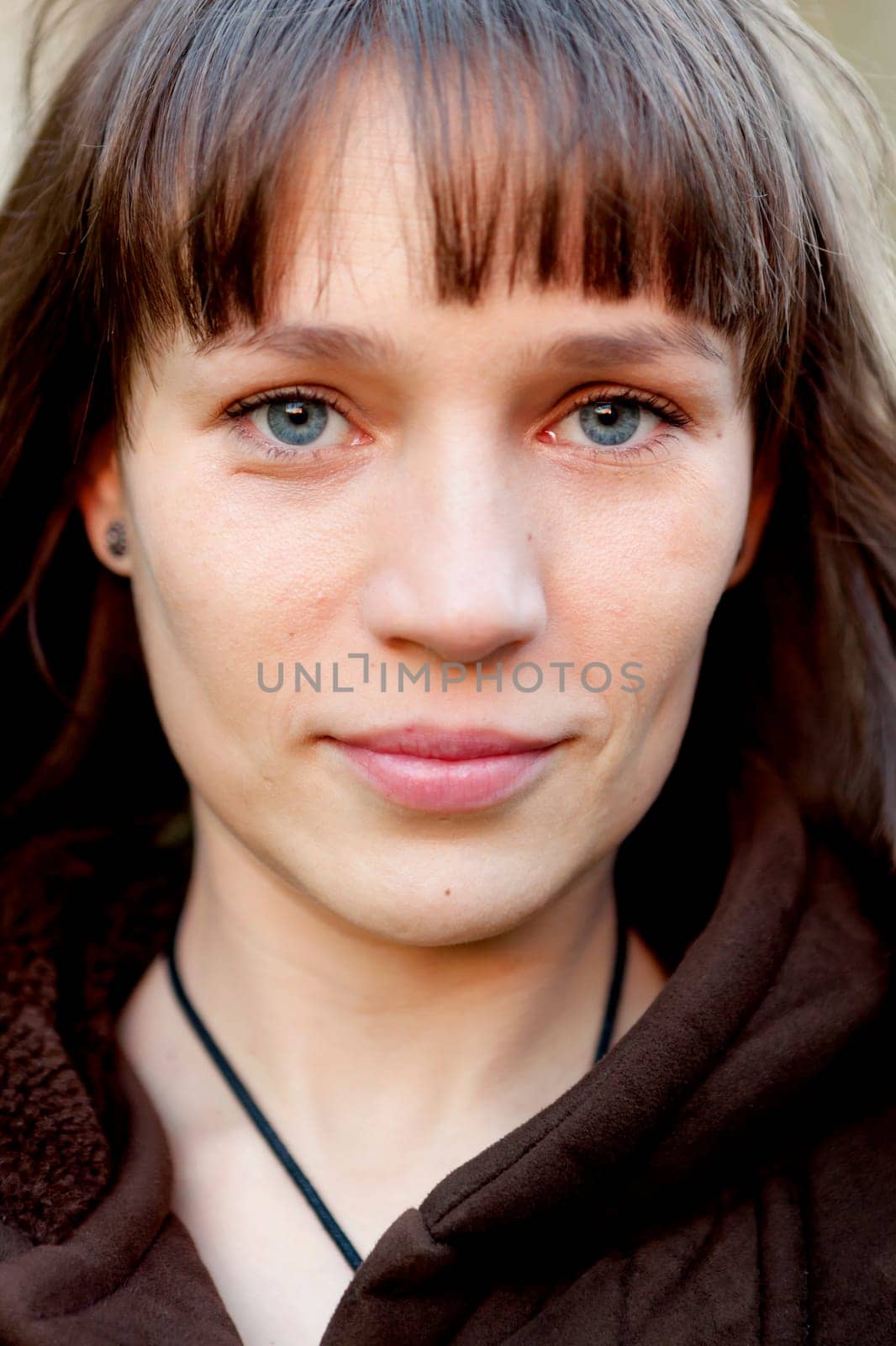 Beautiful brunette woman with blue eyes in the park