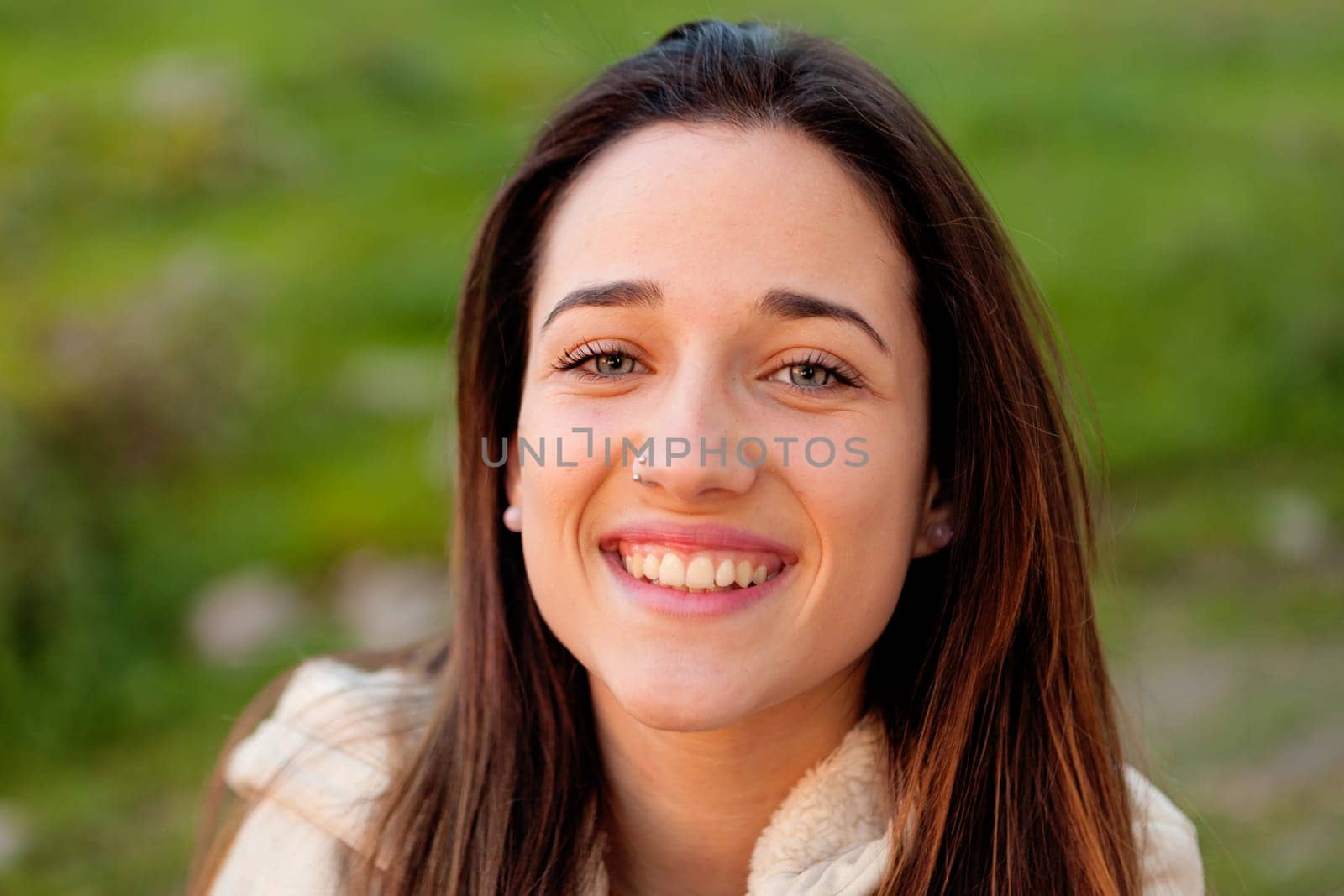 Smiling teen girl outside with a natural green of background