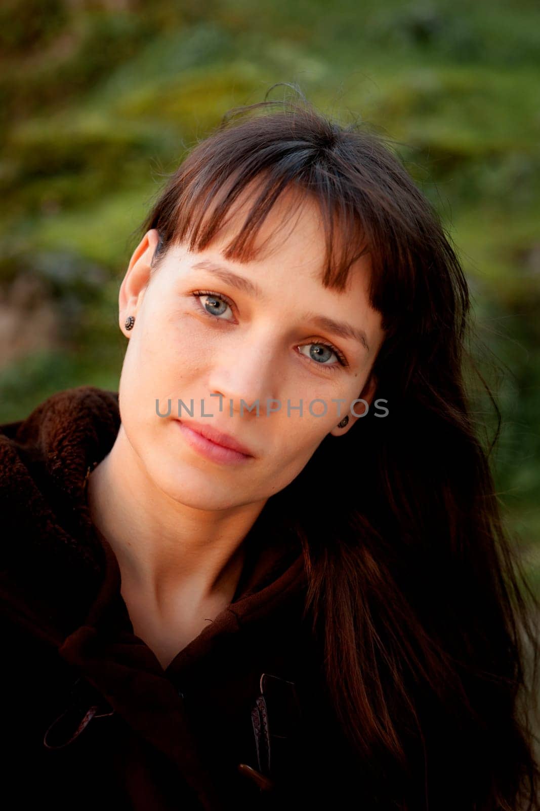 Beautiful brunette woman with blue eyes in the park