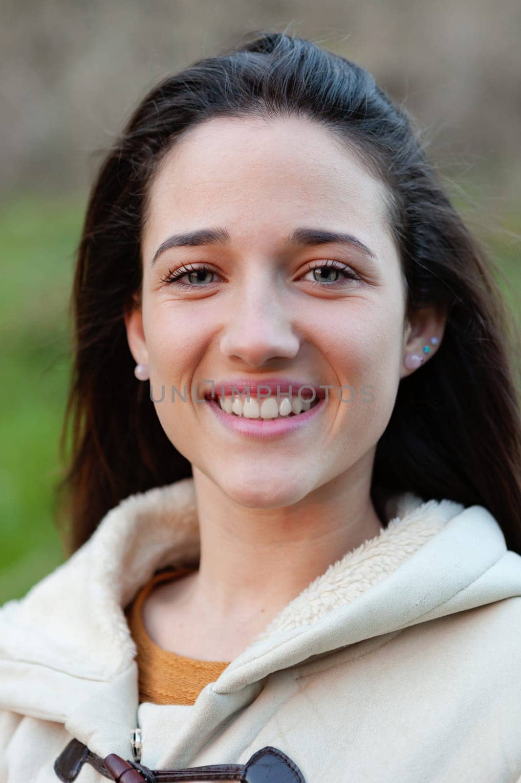 Smiling teen girl outside with a natural green of background