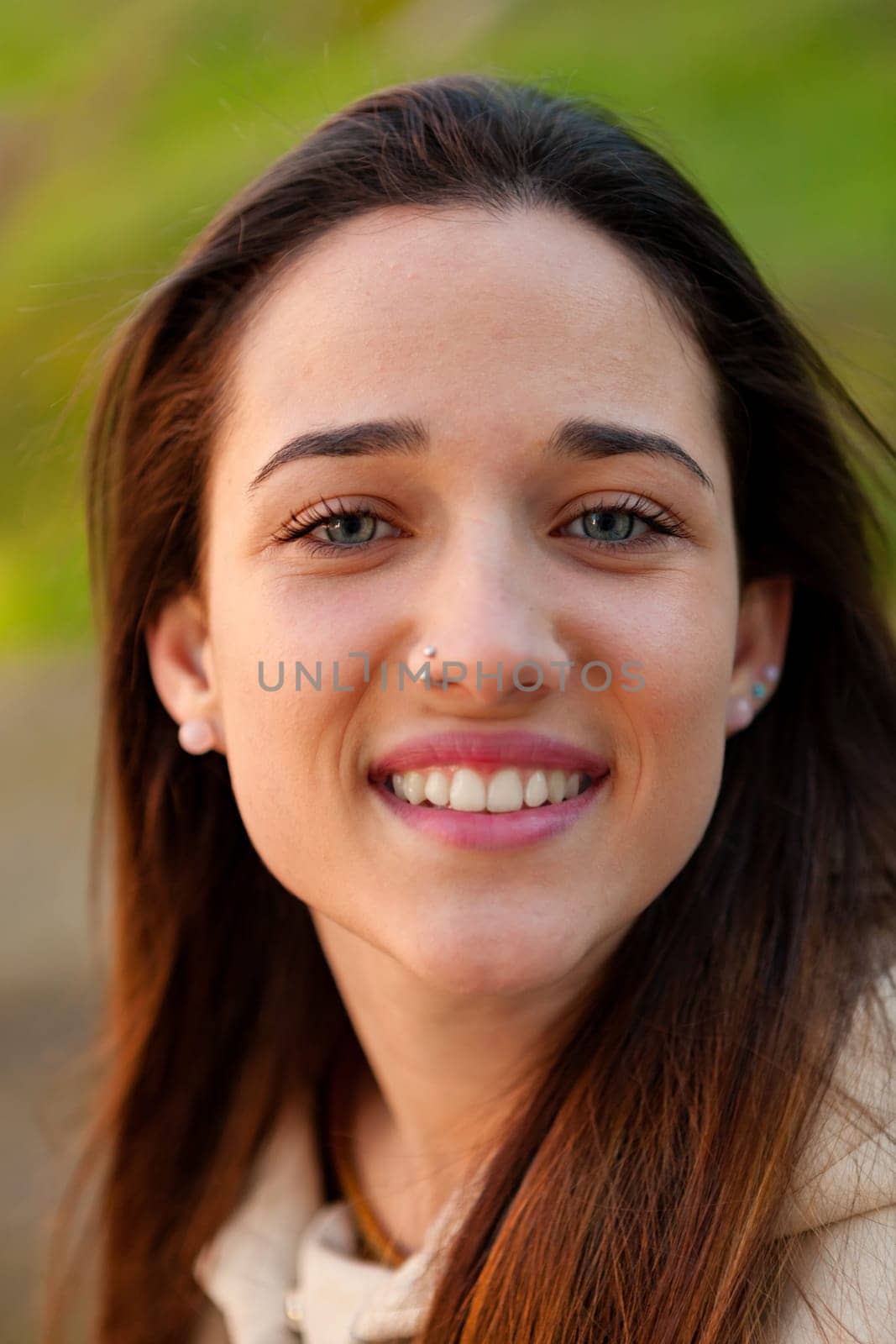 Smiling teen girl outside with a natural green of background