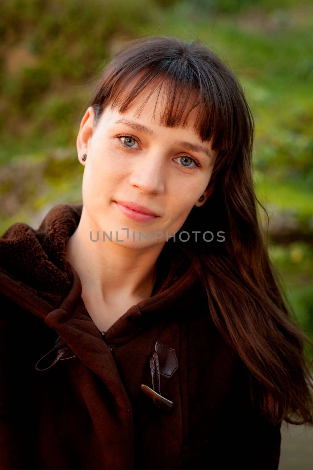 Beautiful brunette woman with blue eyes in the park