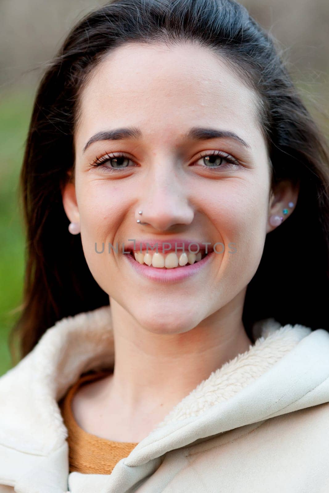 Smiling teen girl outside with a natural green of background