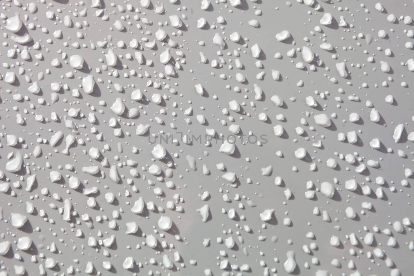 Water drops from rain over a white surface
