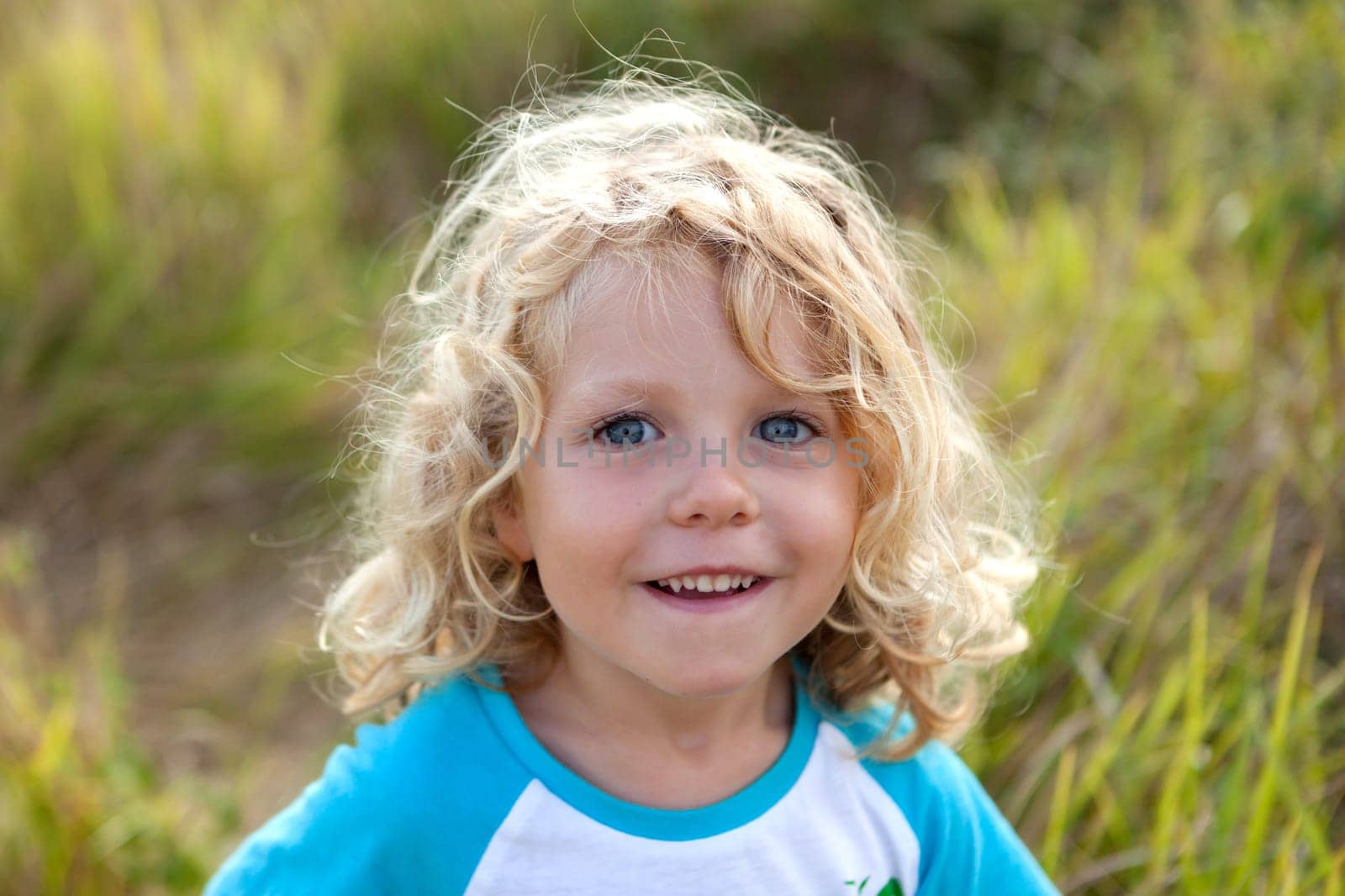 Small child with long blond hair enjoying of a sunny day