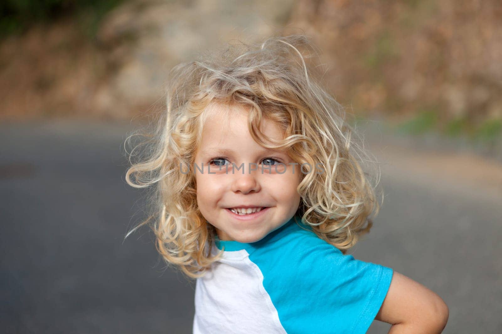 Small child with long blond hair enjoying of a sunny day