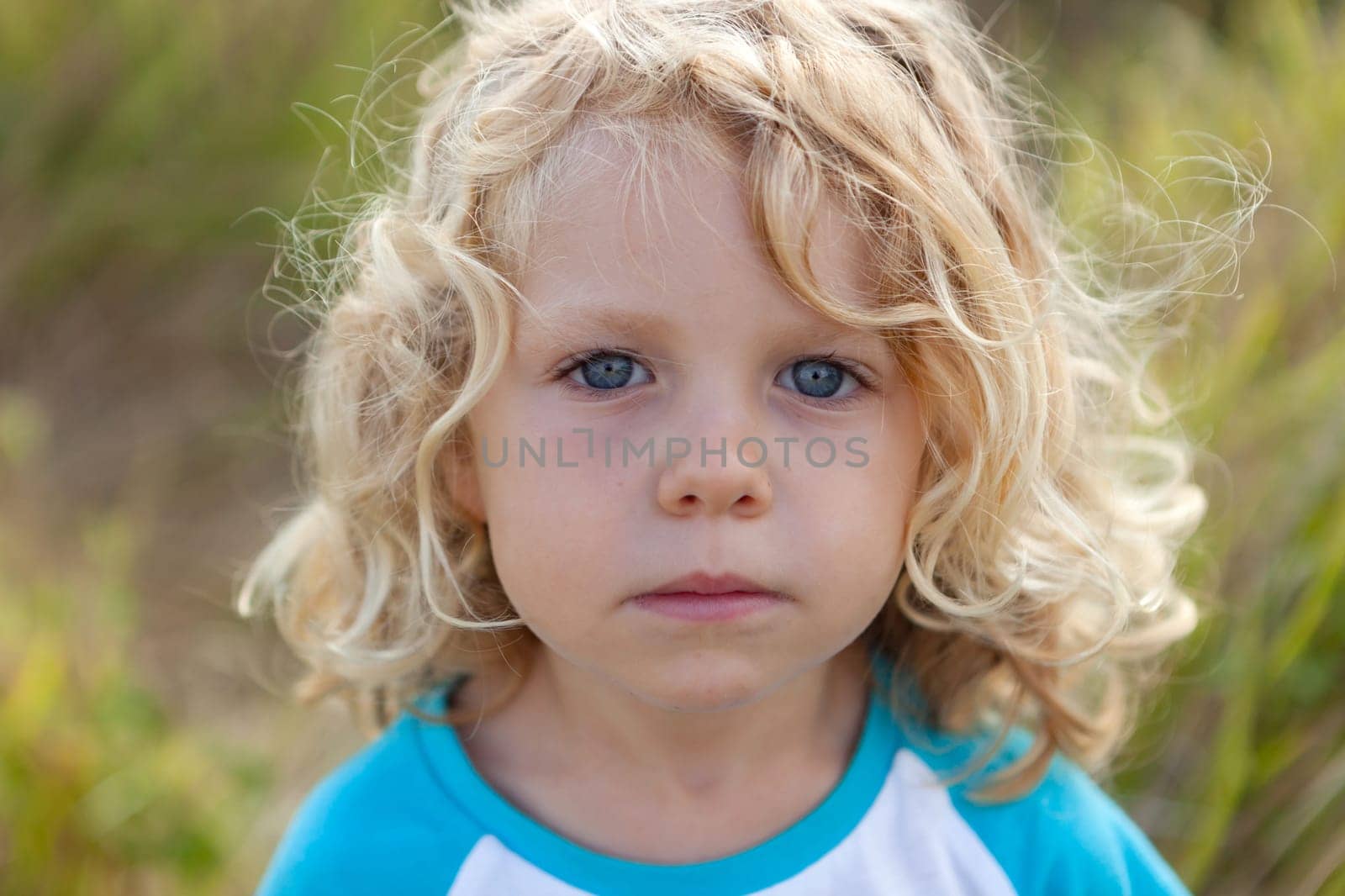 Small child with long blond hair enjoying of a sunny day