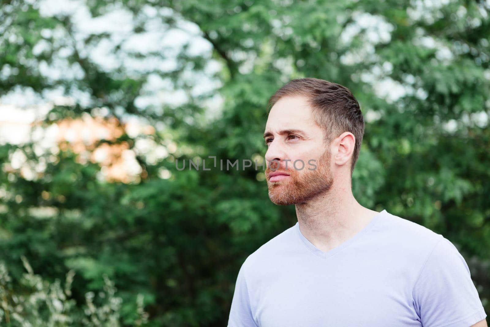 Portrait of a casual bearded man with many plants of background