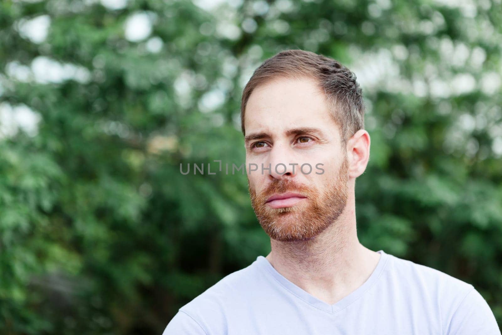 Portrait of a casual bearded man with many plants of background