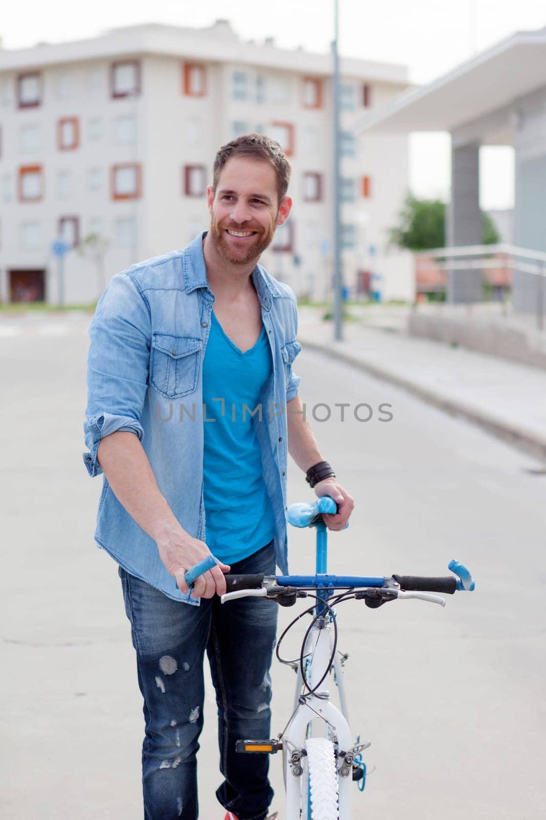 Casual guy next to a vintage bicycle in the city