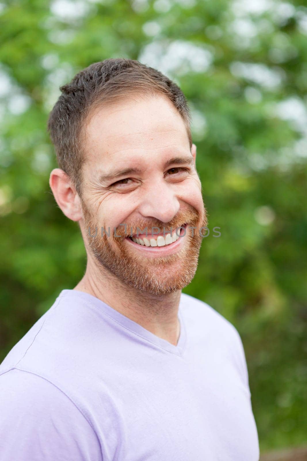 Portrait of a casual bearded man with many plants of background