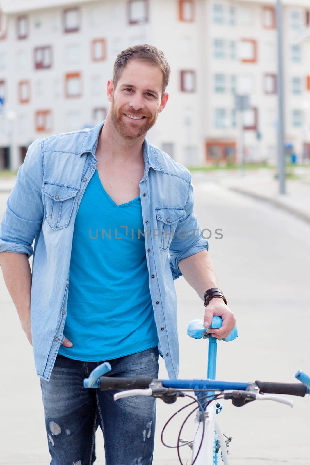 Casual guy next to a vintage bicycle in the city
