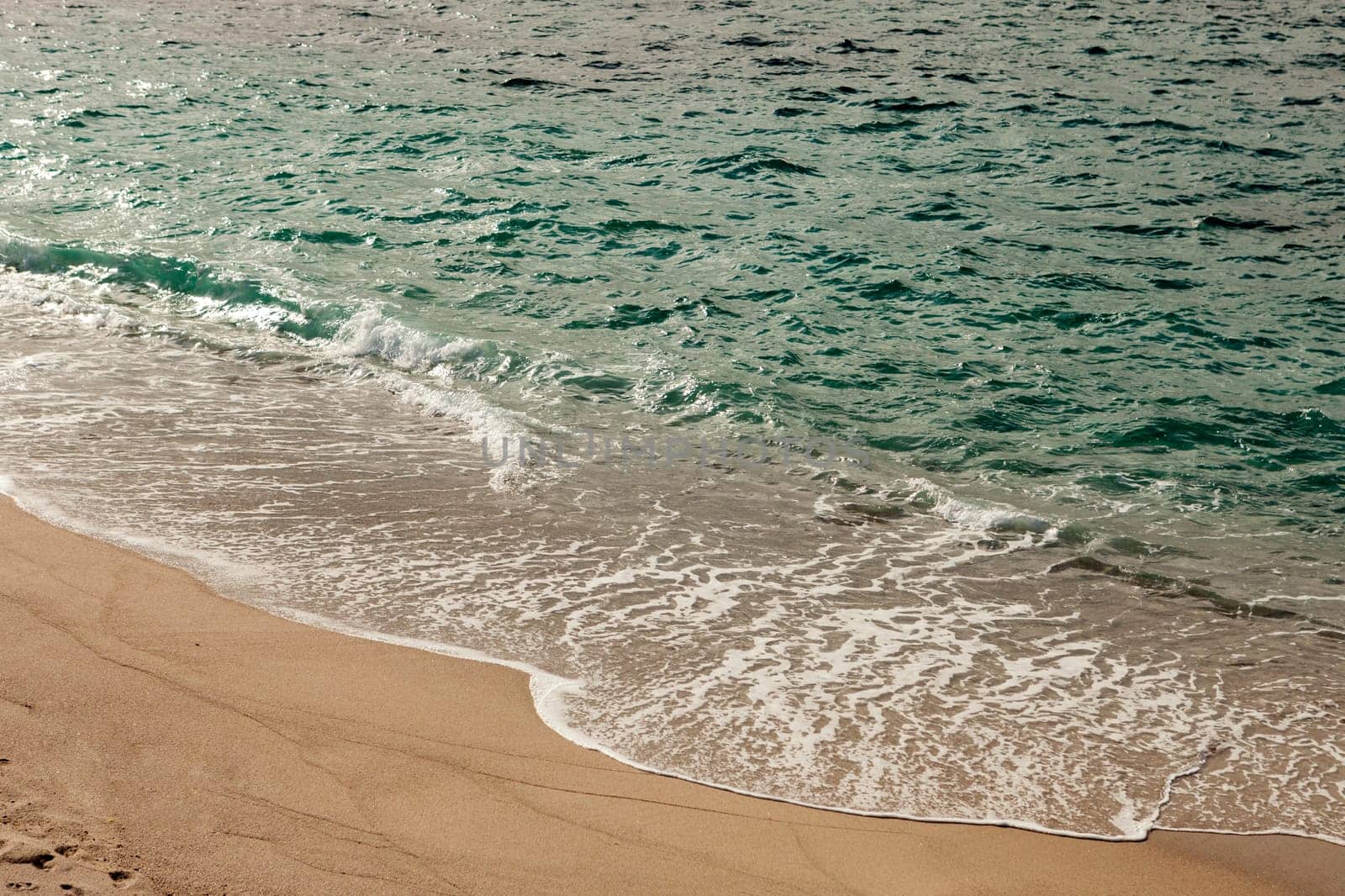 Foamed blue waves breaking in the beach