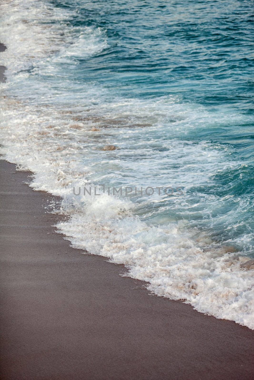 Foamed blue waves breaking in the beach