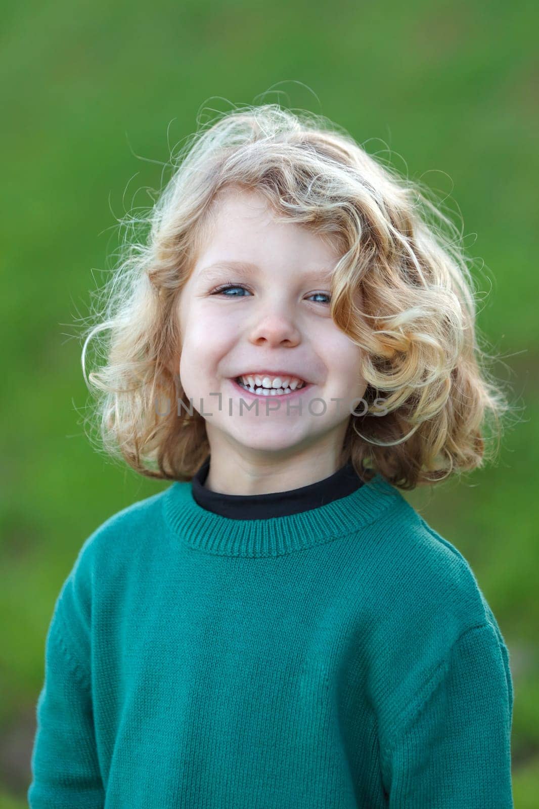 Small child with long blond hair enjoying of a sunny day