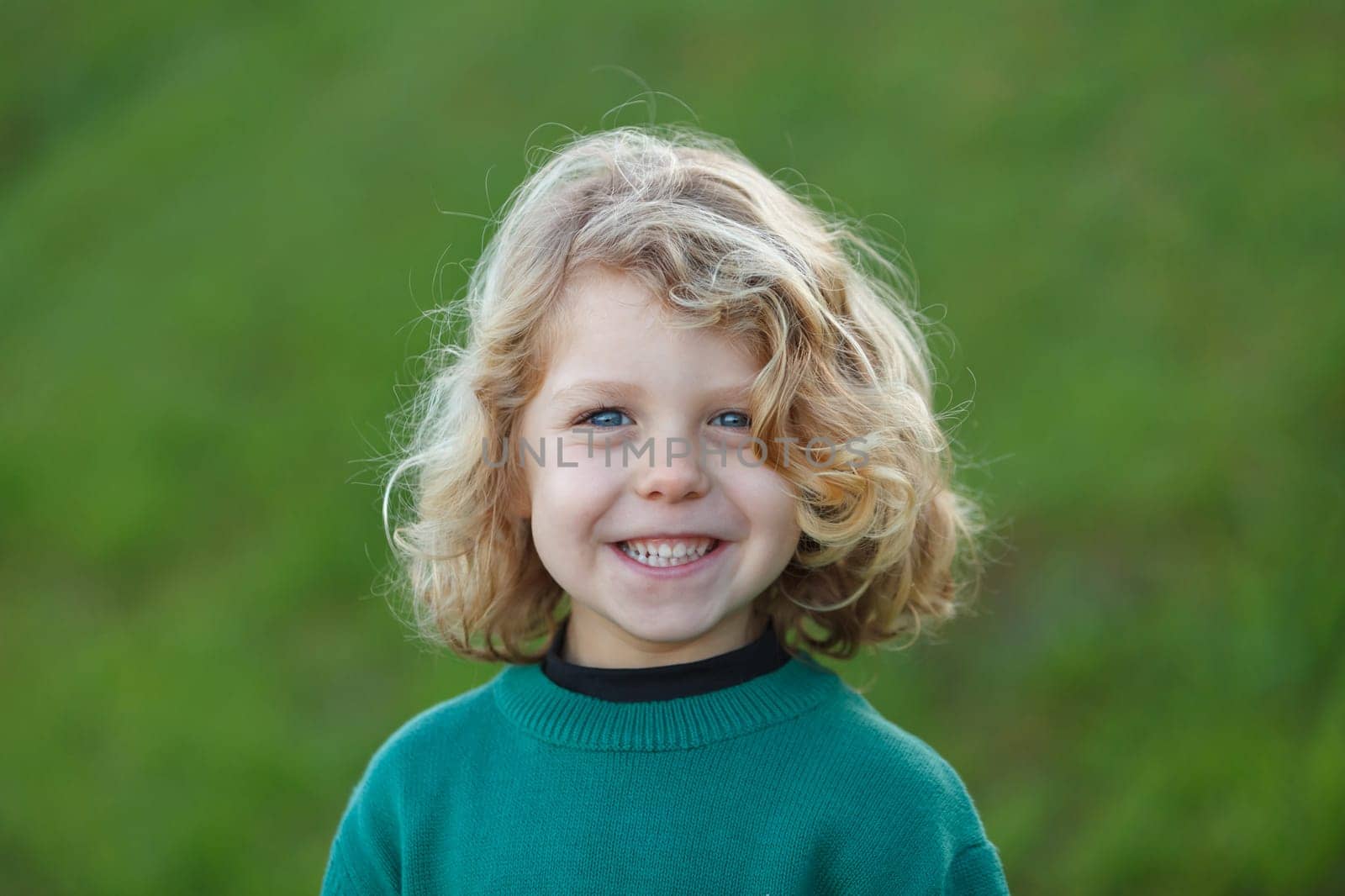 Small child with long blond hair enjoying of a sunny day