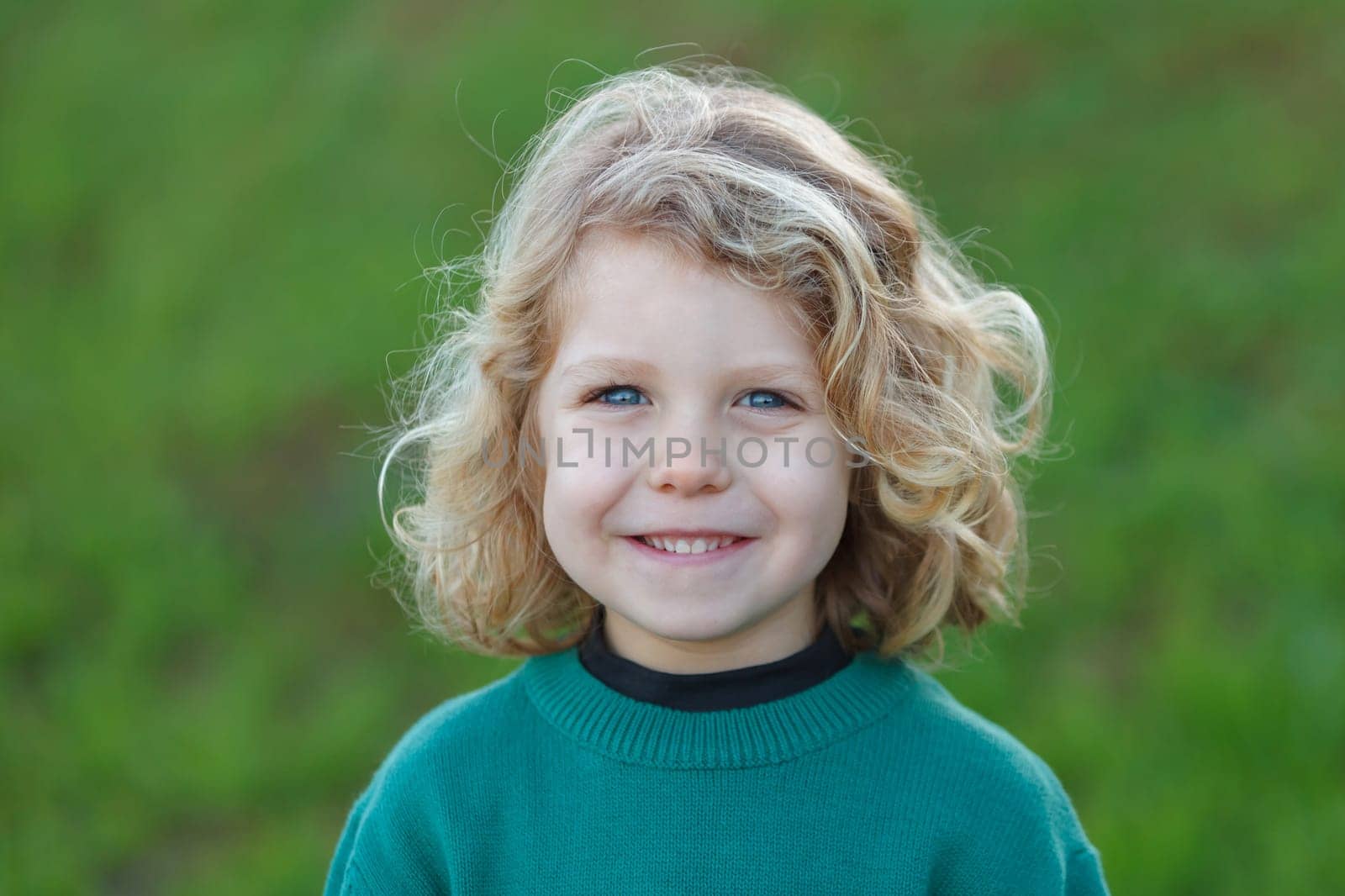 Small child with long blond hair enjoying of a sunny day