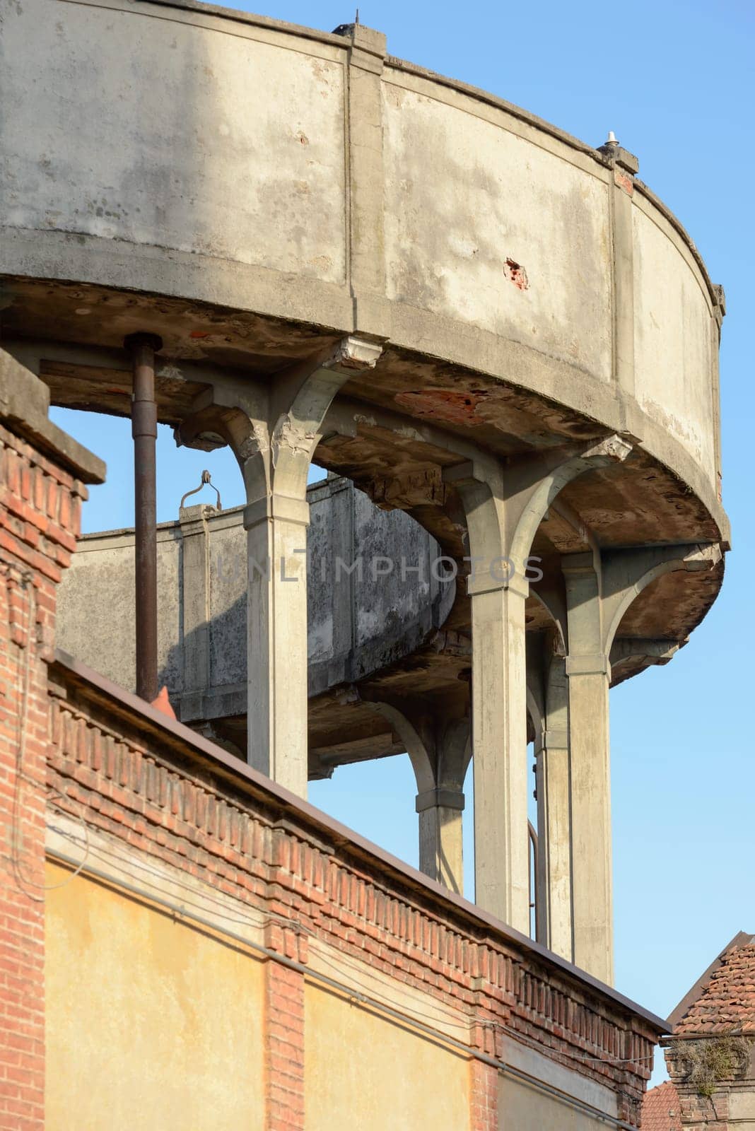 detail of thin plillars and  brick decoration of water tank in old industrial village, shot in winter at Crespi Adda, Capriate, Lombardy, Italy