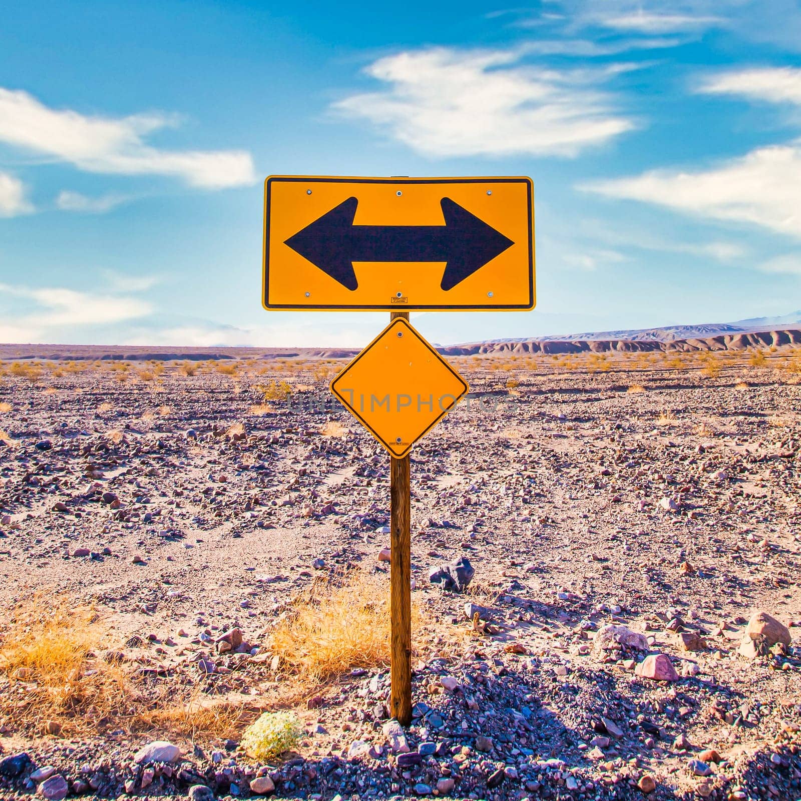 Directional sign in the desert with scenic blue sky and wide horizon. Concept for trip, freedom, holiday and transportation.