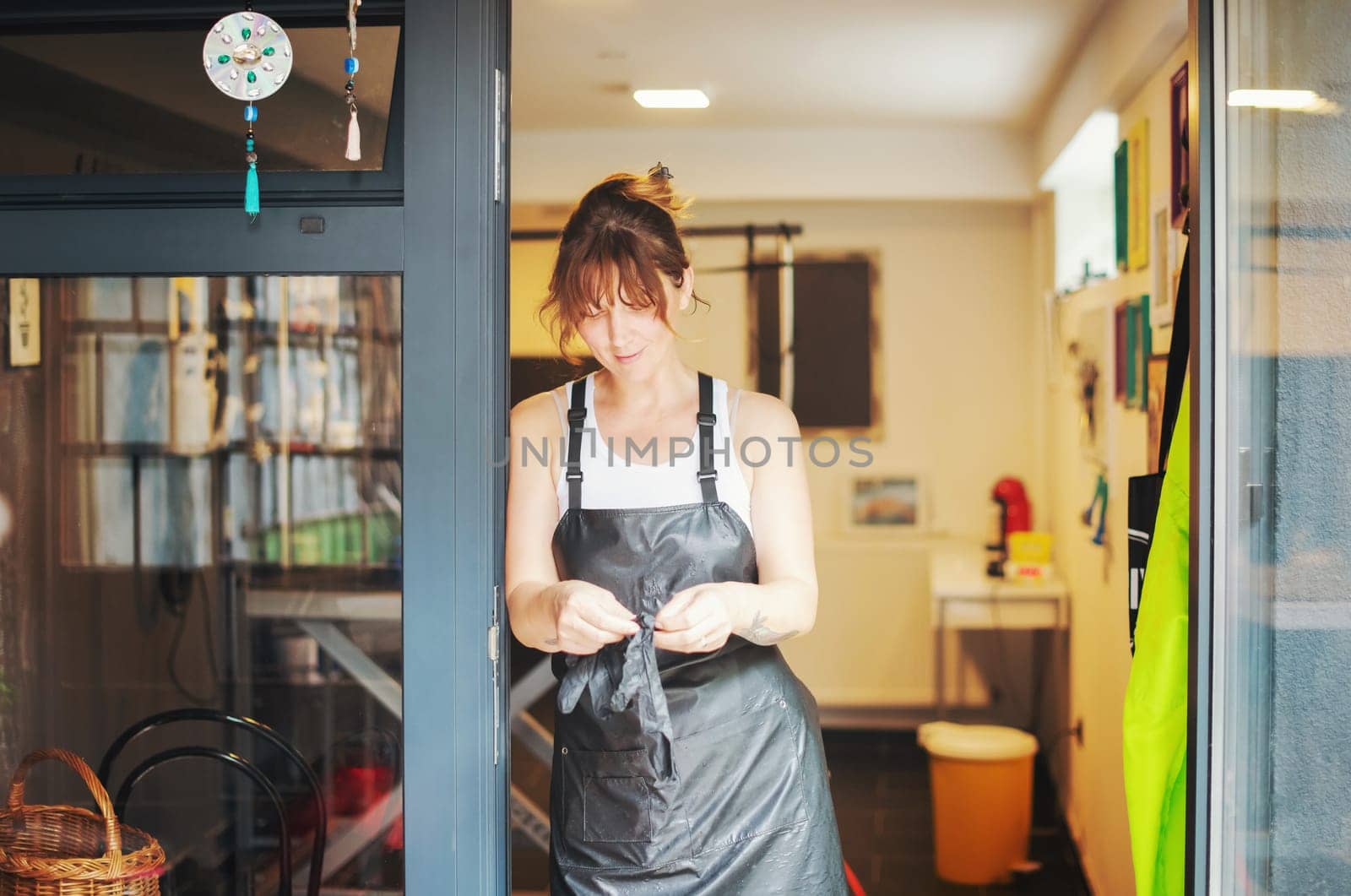 portrait of professional pet hairdresser hipster woman with tattoos while standing at the door of her beauty salon for animals