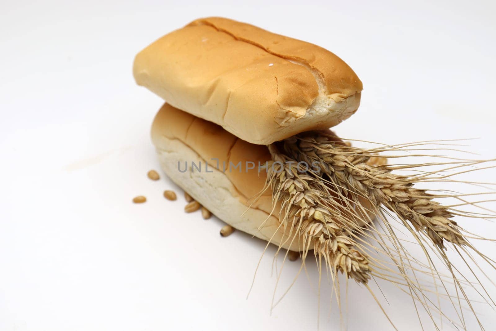 tasty and healthy bread and ripe wheat on white background