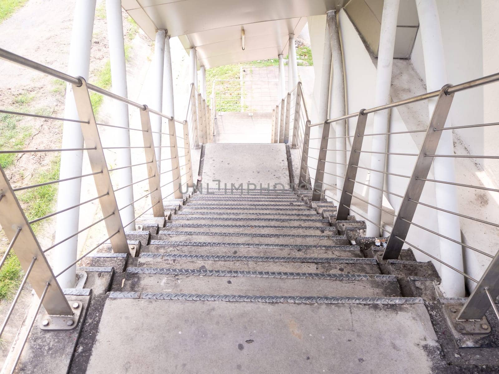 staircase for descending from footbridge. The concrete overpass for crossing the road.