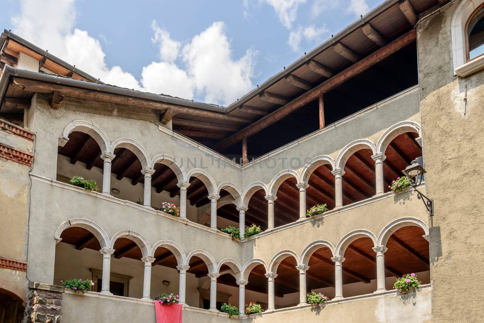 cityscape of historical village with old building arched loggias on stone mullions, shot in bright summer light at Gromo, Bergamo, Lombardy, Italy.