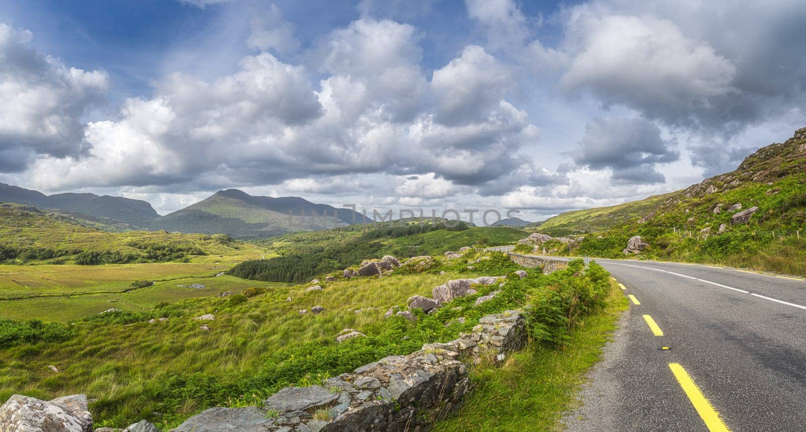 Winding road through Molls Gap with Owenreagh River valley, MacGillycuddys Reeks mountains and sheep farms, Wild Atlantic Way, Ring of Kerry Ireland