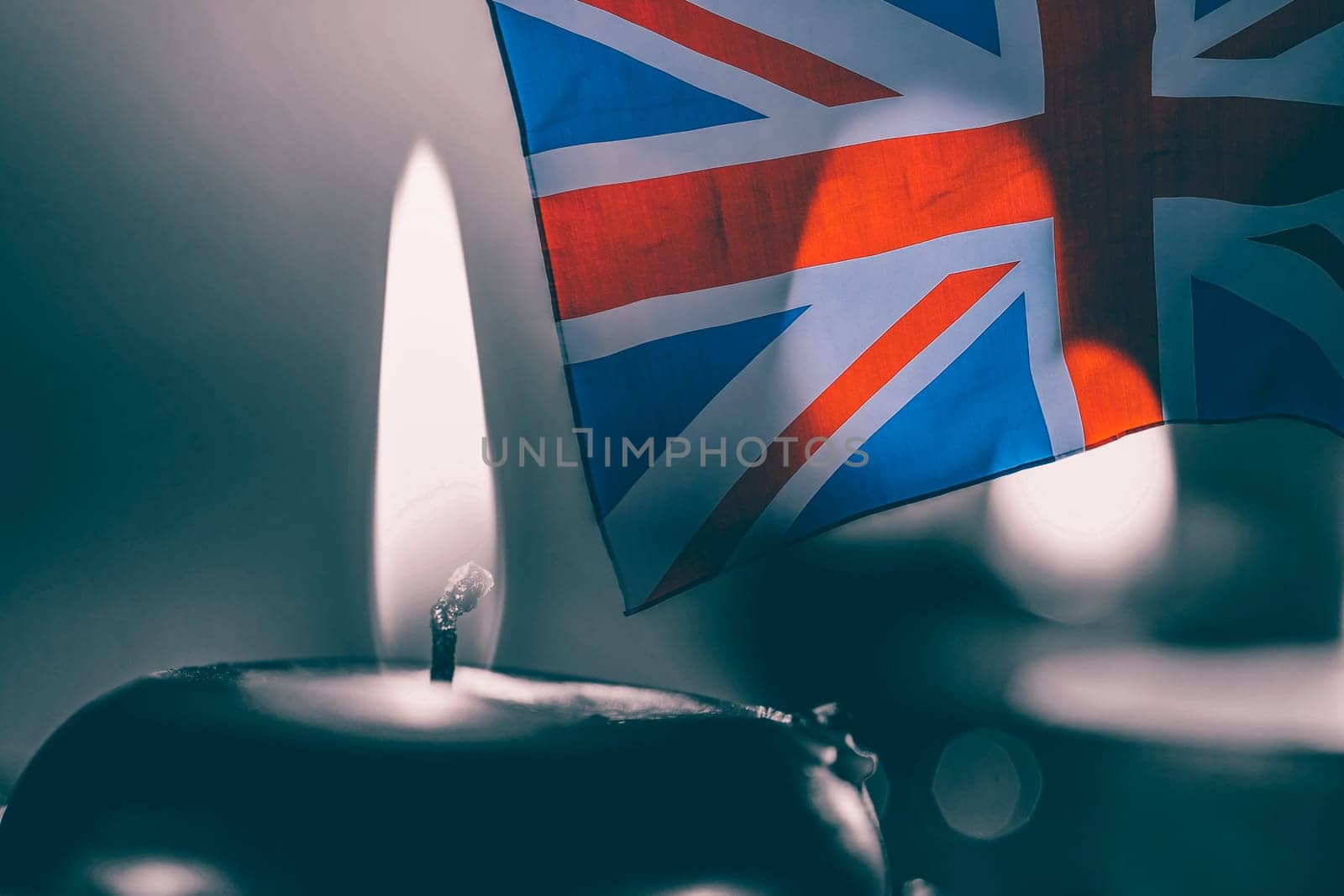 Burning candle and UK flag. The concept of mourning and sorrow in the country, UK national mourning