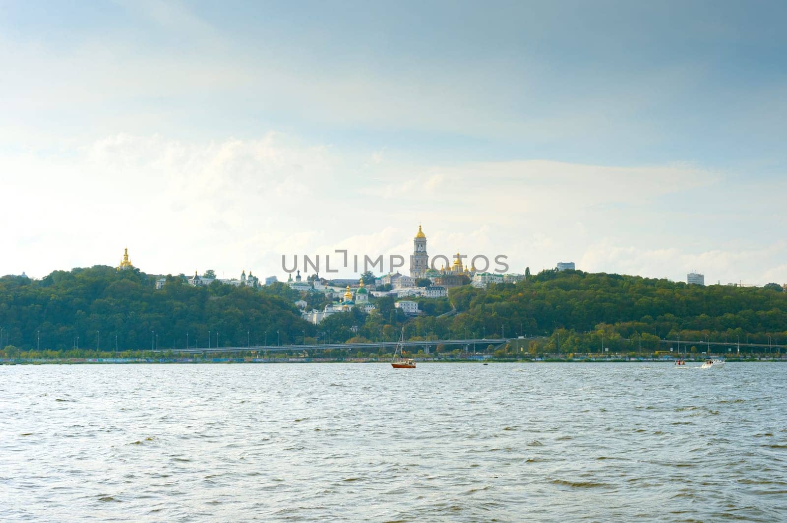 View of Kyiv-Pechersk lavra. Yacht on the Dnipro river. Kyiv, Ukraine
